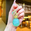 Iridescent pineapple keychain charm featuring translucent resin and gold metal leaf detail - Green (Gold Hardware)