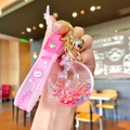 Macro detail of a pink rabbit star moon bottle keychain with shiny gold bell - Red Luminous Rabbit