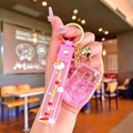 Detail of pink unicorn liquid glitter keychain with silicone strap and golden bell charm - Pink Luminous Bubble Bead Coke Can