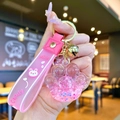 Detailed view of pink cat paw liquid glitter keychain with silicone milk candy strap - Pink Luminous Bubble Bead Cat Paw