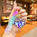 Close-up of heart-shaped liquid keychain with purple sequins and a golden bell - Gradient Strap Purple Snowflake Heart