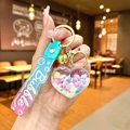 Detail of heart liquid quicksand keychain with pink and blue beads and golden bell - Gradient Strap White Snowflake Heart