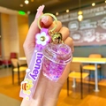 Close-up of purple heart-shaped acrylic shaker keychain with liquid sand and honey strap - Purple