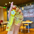 Detailed view of yellow acrylic yogurt cup keychain with honey rubber wristlet strap - Yellow