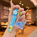 Detail of blue quicksand keychain with silicone strap honey bee charm and gold bell - Blue Luminous Bubble Bead Book