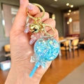 Llavero de piruleta con purpurina azul y cascabel dorado en anilla de metal - Piruleta Azul Fluorescente