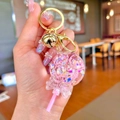 Llavero de piruleta con purpurina líquida, lazo rosa y colgante de campana dorada - Piruleta Rosa Fluorescente