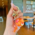 Cute golden keychain with an orange transparent lollipop charm and a large bell - Orange Snowflake Lollipop