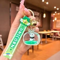 Macro detail of acrylic panda keychain with green liquid quicksand and gold bell - Panda TV / Green