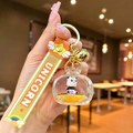Close-up of a liquid panda keychain featuring yellow sand, sequins, and a golden bell - Panda TV / Orange