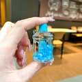 Makroaufnahme eines blauen Eimer-Schlüsselanhängers mit Flüssigglitzer in der Hand - Leuchtende Blasenperlen Eimer (Ohne Schlüsselanhänger) / Blau