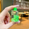 Close-up of green bucket-shaped keychain featuring liquid glitter and star-shaped sequins - Luminous Bubble Beads Bucket (Without Keychain) / Green
