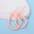 Macro detail of two peach silicone cable ties with non-slip texture on a white stone base - Ellipse / 2 Pcs/Set / Nude Pink