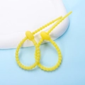 Detail of two yellow adjustable silicone cable ties with beaded design on a blue backdrop - Ellipse / 2 Pcs/Set / Light Yellow