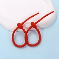 Macro view of red silicone cable ties with non-slip ridges for versatile cord organization - Ellipse / 2 Pcs/Set / Red