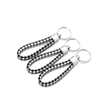 Gedetailleerd overzicht van drie zwart-witte gevlochten lederen sleutelhangers met ringen - Zwart Wit