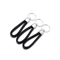 Detailweergave van drie gevlochten PU-lederen sleutelhangers met zilveren metalen ringen - Zwart