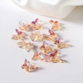 Macro detail of iridescent AB resin butterfly charms with colorful rainbow light effects - Orange