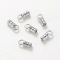 Close-up of polished silver star embossed cylinder cord end caps for jewelry making - 2.5x7mm (1.5mm Hole) - 10 Pieces/Pack / White Gold