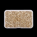 Macro shot of irregular metallic gold glass stones in a clear rectangular container - Champagne