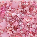 Makroaufnahme von rosa Acrylperlen in Stern-, Blumen- und Herzform für DIY-Schmuck - Rosa Serie