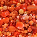 Makroaufnahme verschiedener orangefarbener Perlen aus Acryl und Harz für DIY-Schmuck - Orangefarbene Serie