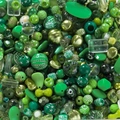 Nahaufnahme grüner Acrylperlen für DIY-Schmuck mit verschiedenen Formen und Texturen - Dunkelgrüne Töne