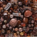 Makroaufnahme von braunen Acrylperlen in Herz- und Sternform für DIY-Schmuck - Dunkelbraune Töne