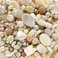 Nahaufnahme von DIY-Schmuckperlen in Creme und Gold mit Herz- und Gänseblümchenform - Beige Serie