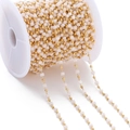 Macro shot of gold metal beads and pink crystal chain wrapped on a plastic spool - Cream Colored (Imitation Gold Chain)