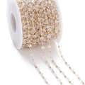 Detailed close-up of crystal square beads and gold round beads chain on a spool - White (KC Gold Chain)