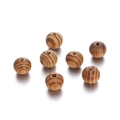 Macro detail of natural maple wood beads with grain texture and pre-drilled holes for DIY - 20mm