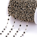 Detail van gouden ketting met zwarte gezette zirkoonstenen op een witte spoel - Pakket van 1 Meter (6.8mm) / KC Goud Ketting Zwarte Zirconia