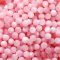 Macro shot of pink resin cat eye round beads for handmade jewelry and necklaces - Pink