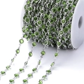 Detailopname van een zilveren koperen ketting met groene zirkoon op een witte spoel - Pakket van 1 Meter (6.8mm) / Wit K Ketting Fruitgroene Zirconia