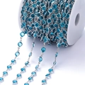 Detailopname van de verzilverde ketting met blauwe zirkoonstenen op een witte spoel - Pakket van 1 Meter (6.8mm) / Wit K Ketting Meerblauw Zirconia