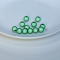 Dettaglio macro di perline verdi riflettenti laser per gioielli fai-da-te e catene - Verde Erba