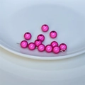 Vista macro di perle acriliche rosa fucsia con riflessi metallici per gioielli fai-da-te - Rosa Rosso
