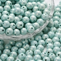 Macro detail of macaron light blue acrylic pearls with glossy finish in a glass bowl - Sky Blue