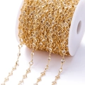 Macro-opname van 1m goudkleurige koperen ketting met zirkoon op een witte plastic spoel - Pakket van 1 Meter (6.8mm) / Goudkleurige Ketting Witte Zirconia