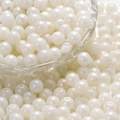Macro shot of white acrylic pearl beads with threading holes for DIY jewelry making - White