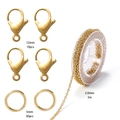 Makroaufnahme von 12mm Karabinerverschlüssen, 5mm Ringen und 2mm Goldkette für DIY-Schmuck - Gold Kreuzkette Material