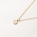 Détail du collier chaîne dorée de 52cm avec pendentif rond en émail blanc et lettre G - Lettre G