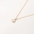 Détail du collier doré de 52cm avec pendentif lettre M sur une surface beige neutre - Lettre M