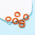 Makroaufnahme orangefarbener matter Rundfederringe für DIY-Schlüsselanhänger und Taschen - Orange