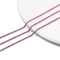 Macro detail of 2mm hot pink rhinestone tennis chain with silver metal base on white porcelain - 2.0mm (1m/Pack) / Silver Base Purplish Red
