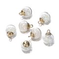 Close-up of luminous glass ball pendants with gold caps for DIY jewelry making - White
