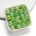 Macro shot of 16mm light green crackle glass beads with AB coating in a small white bowl - Green