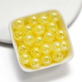 Macro detail of 16mm yellow acrylic beads with cracked texture in a white ceramic dish - Yellow