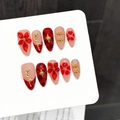 Rote und nude Press-on-Nägel mit 3D-Goldblumen und Sternen-Charms auf weißer Karte - XS / Mittlere Mandelform (3283)